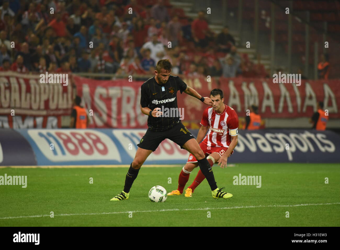 Atene, Grecia. 02oct, 2016. Tomas Pekhart (n. 14) del AEK di proteggere la palla da Luka Milivojevic (NO5) di Olympiacos. Trionfo per Olympiacos (rosso) di calcio, che riescono a vincere AEK (giallo-nero) football team 3-0 per il Greco Super League. Credito: Dimitrios Karvountzis/Pacific Press/Alamy Live News Foto Stock