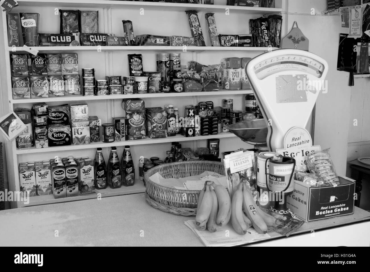 Interno dell'angolo tradizionale negozio con merce sugli scaffali, contatore e vecchie bilance di pesatura Llangian Gwynedd Wales UK Foto Stock