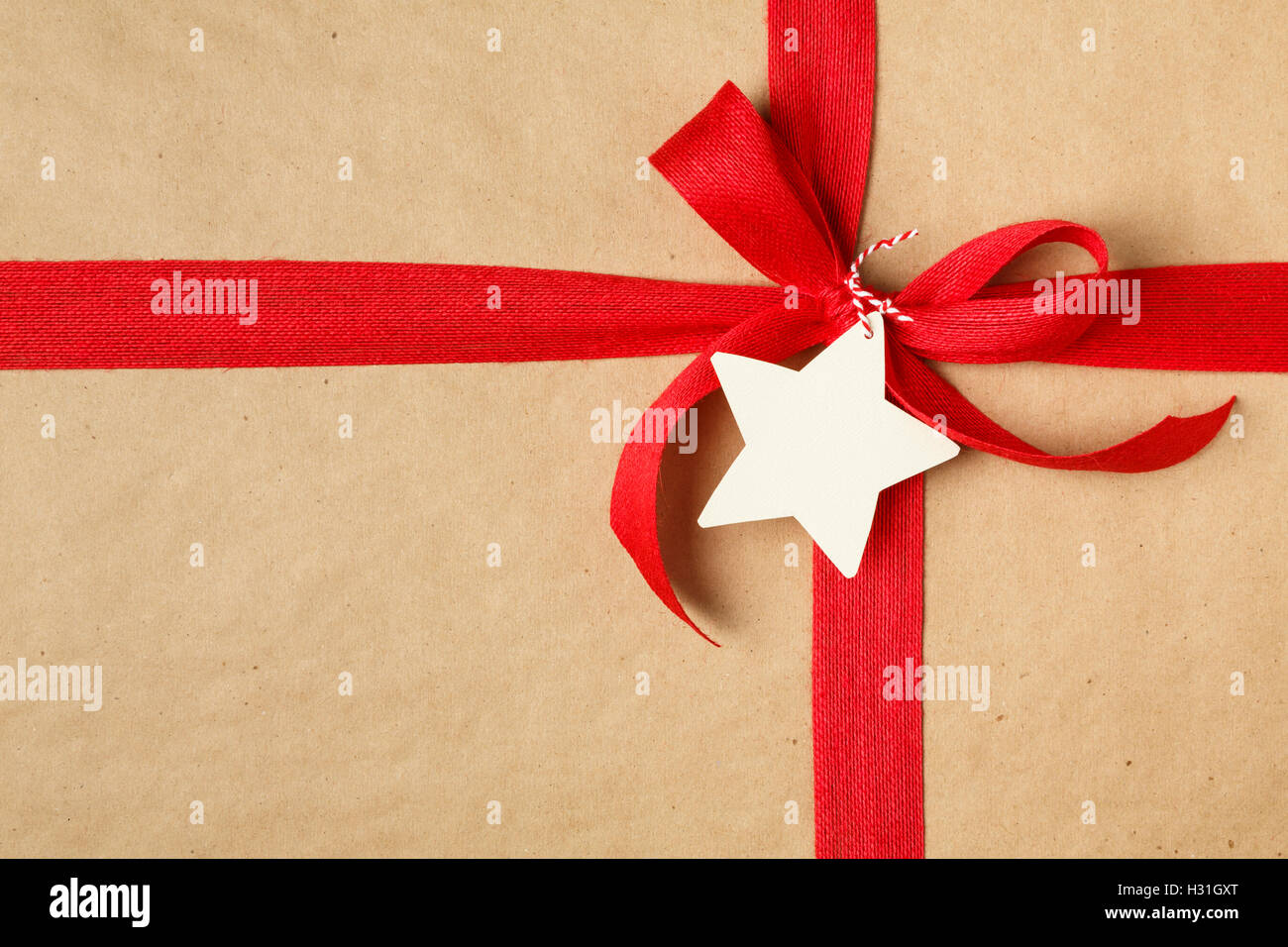 Regalo di natale con la prua e la blank gift tag. Semplice riciclaggio della carta da imballaggio e iuta naturale nastro. Foto Stock