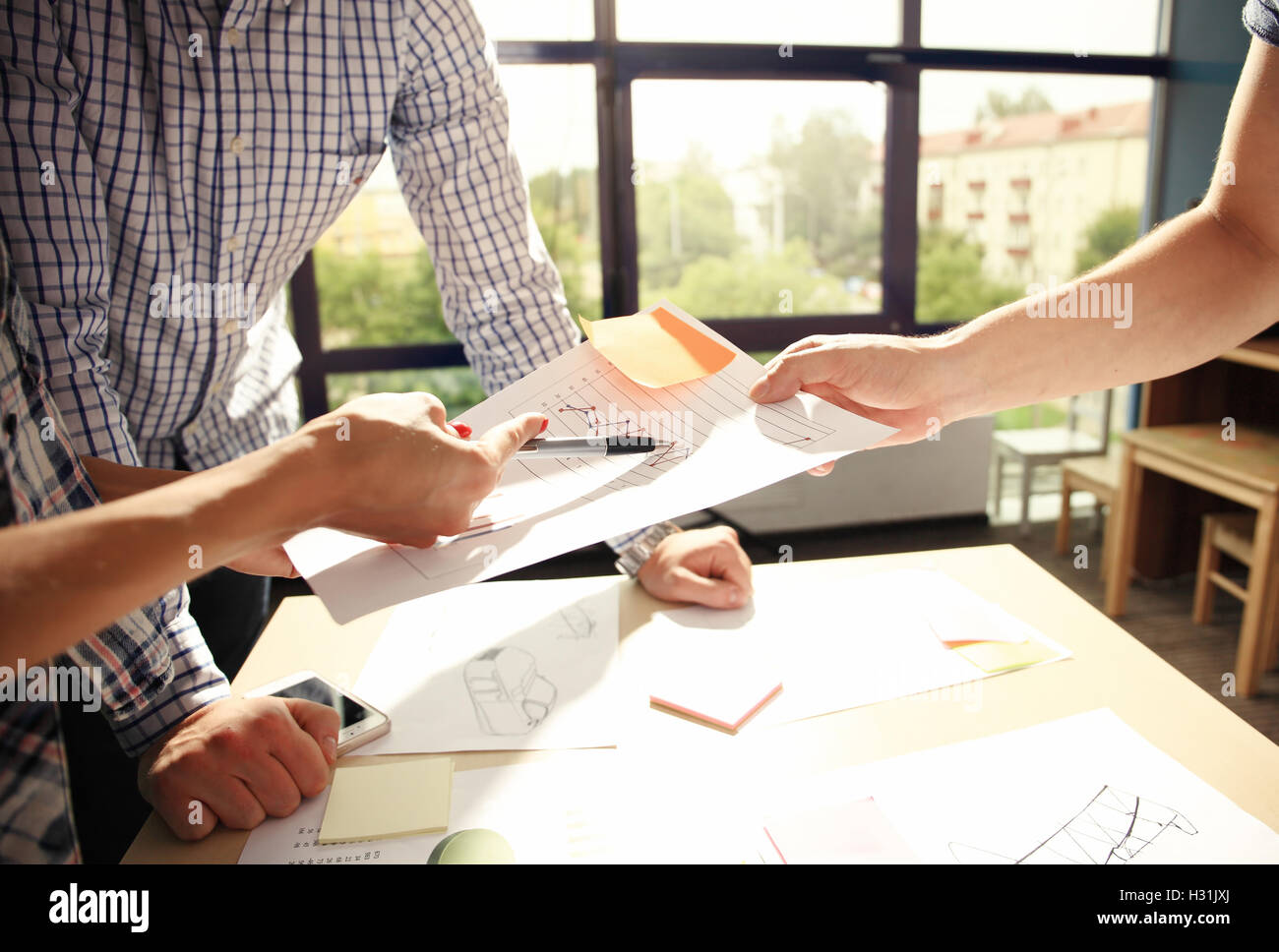 Manager di sesso maschile di mettere le sue idee e redazione di business plan al lavoro,uomo con penne e fogli, rendendo note in documenti, sul tavolo in office,vintage color,luce del mattino ,il fuoco selettivo Foto Stock