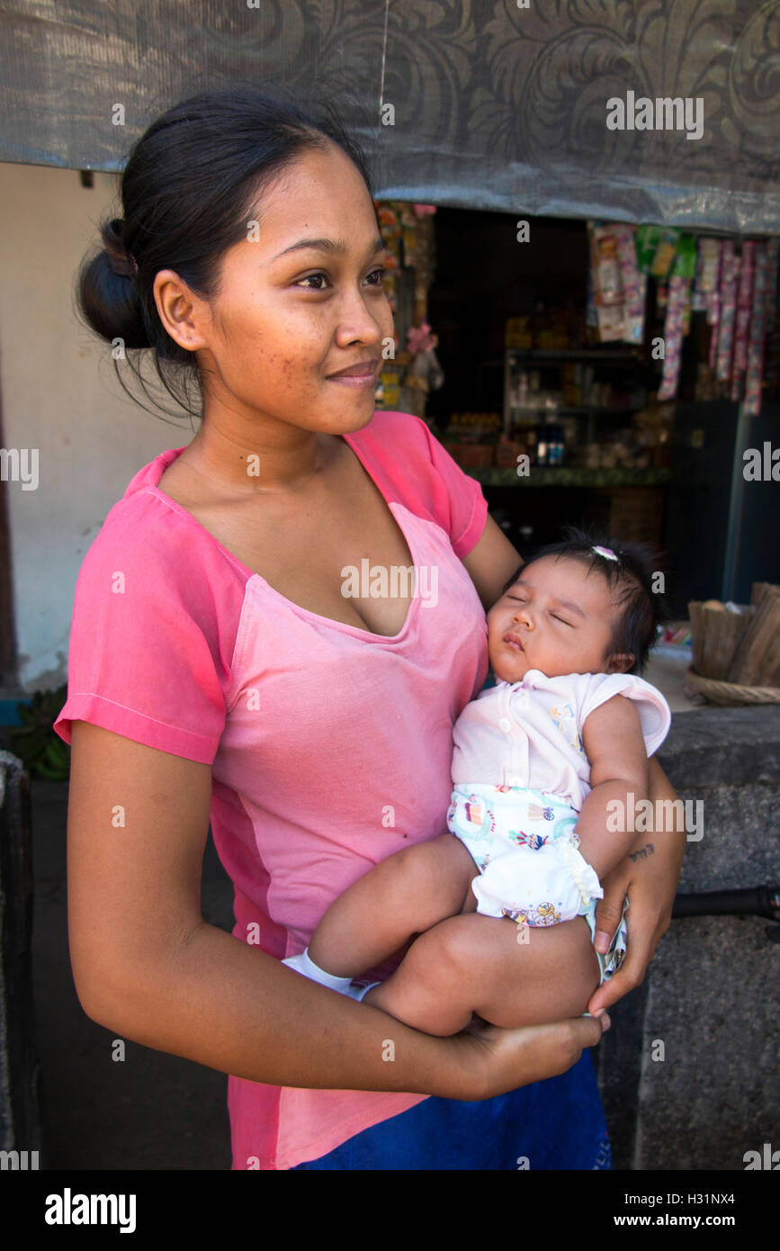Indonesia, Bali, Lovina, Anturan Village, giovane madre con la nostra bambina di armi Foto Stock