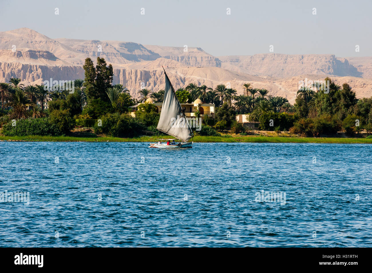 Egitto Luxor. Il Nilo passando a Luxor. Una feluca, una tradizionale barca a vela. Foto Stock