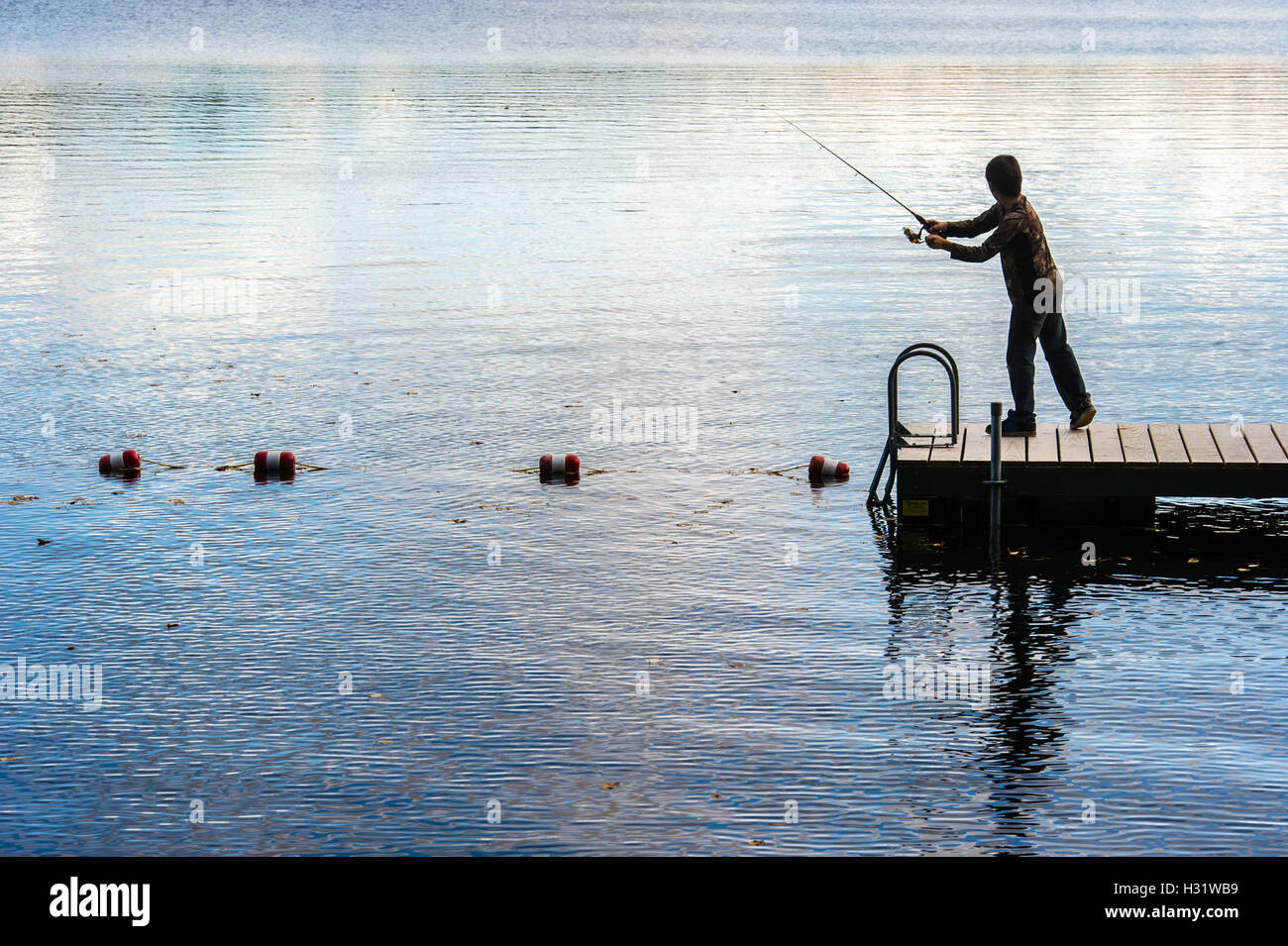 Bambino di pesca sul dock a Bryant stagno nel Maine. Foto Stock