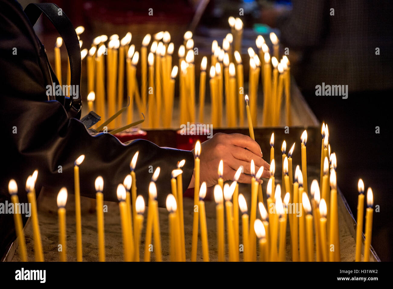 Accendendo candele ad una chiesa Greco Ortodossa in Greektown a Baltimora, Maryland. Foto Stock