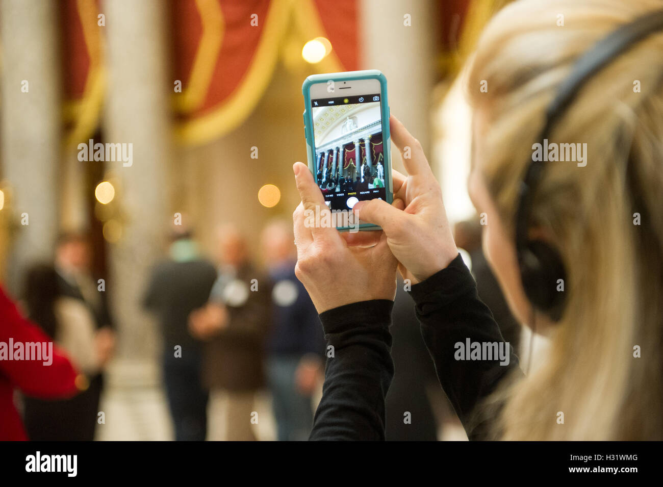 Giovane donna di scattare una foto con il suo iPhone in Campidoglio di Washington DC. Foto Stock