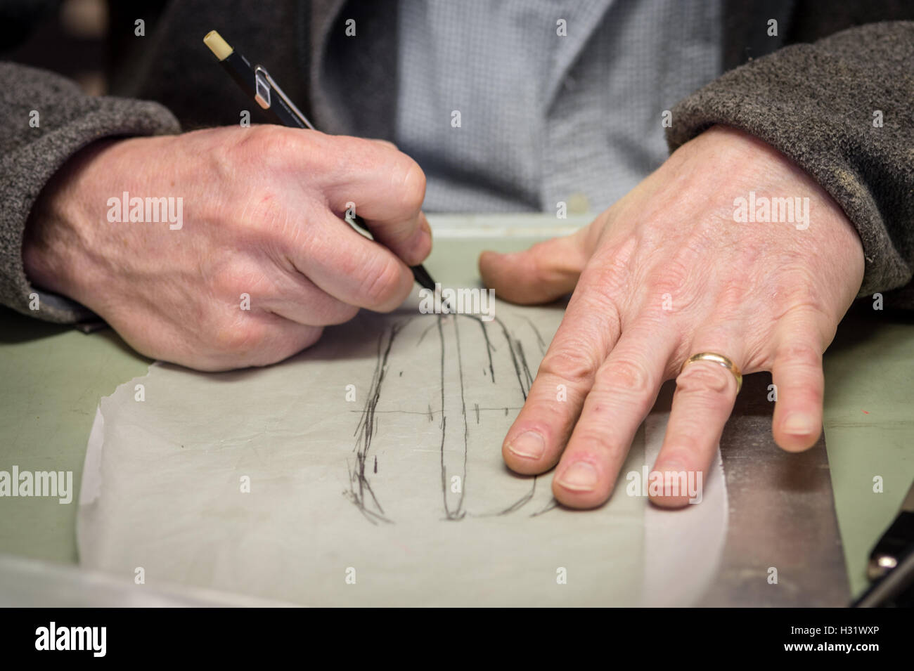 Un uomo del disegno a mano uno schizzo su carta trasparente. Foto Stock
