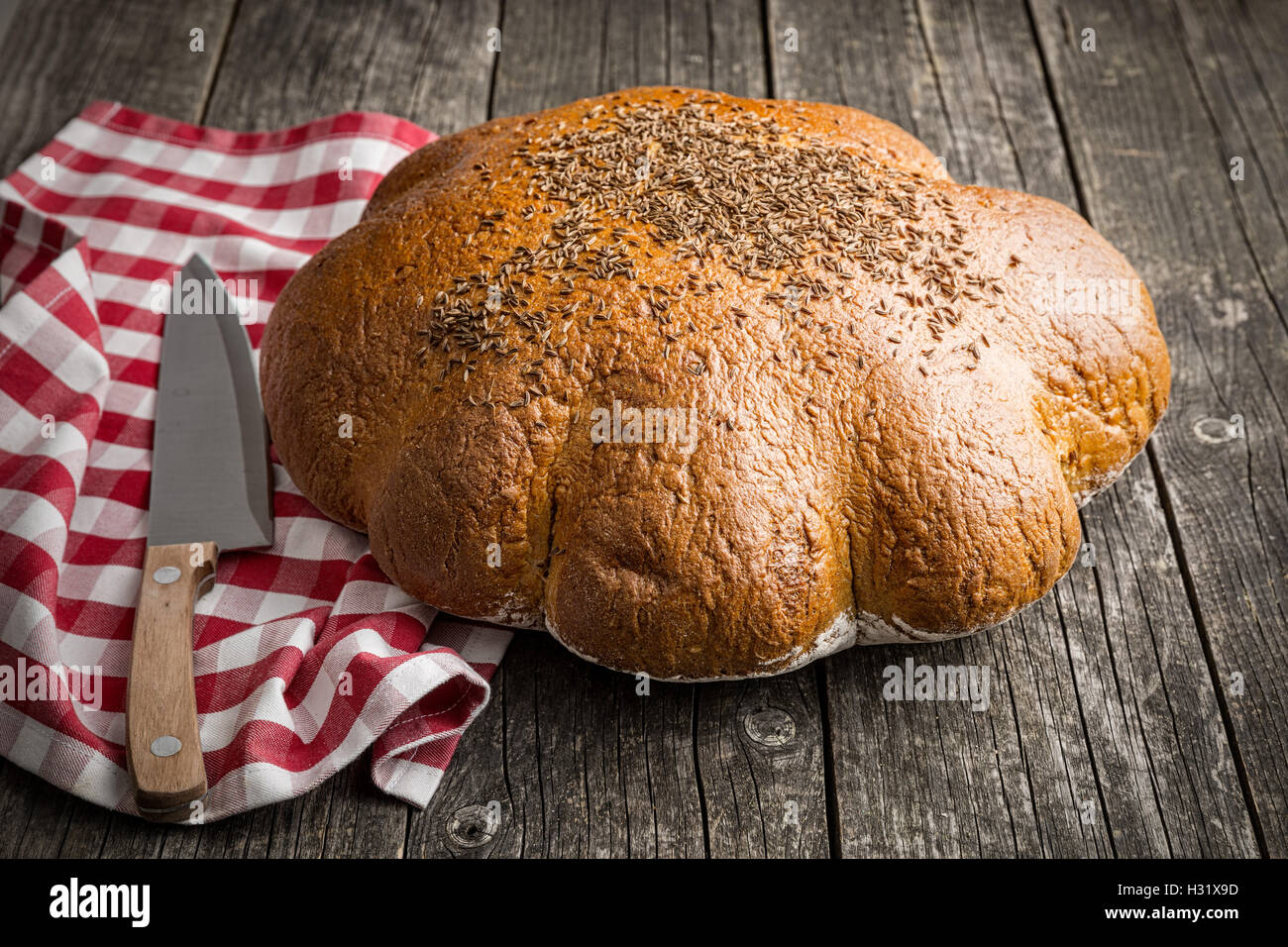 Grande pagnotta di pane sul vecchio tavolo in legno. Foto Stock