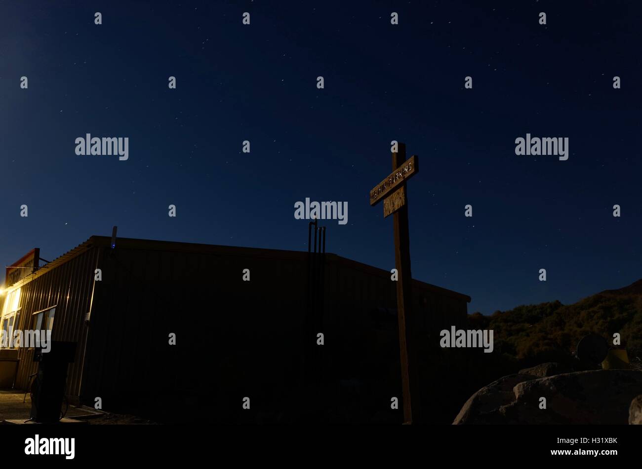 Un simbolo di parcheggio e general store nel mezzo del deserto deserto città di notte Foto Stock