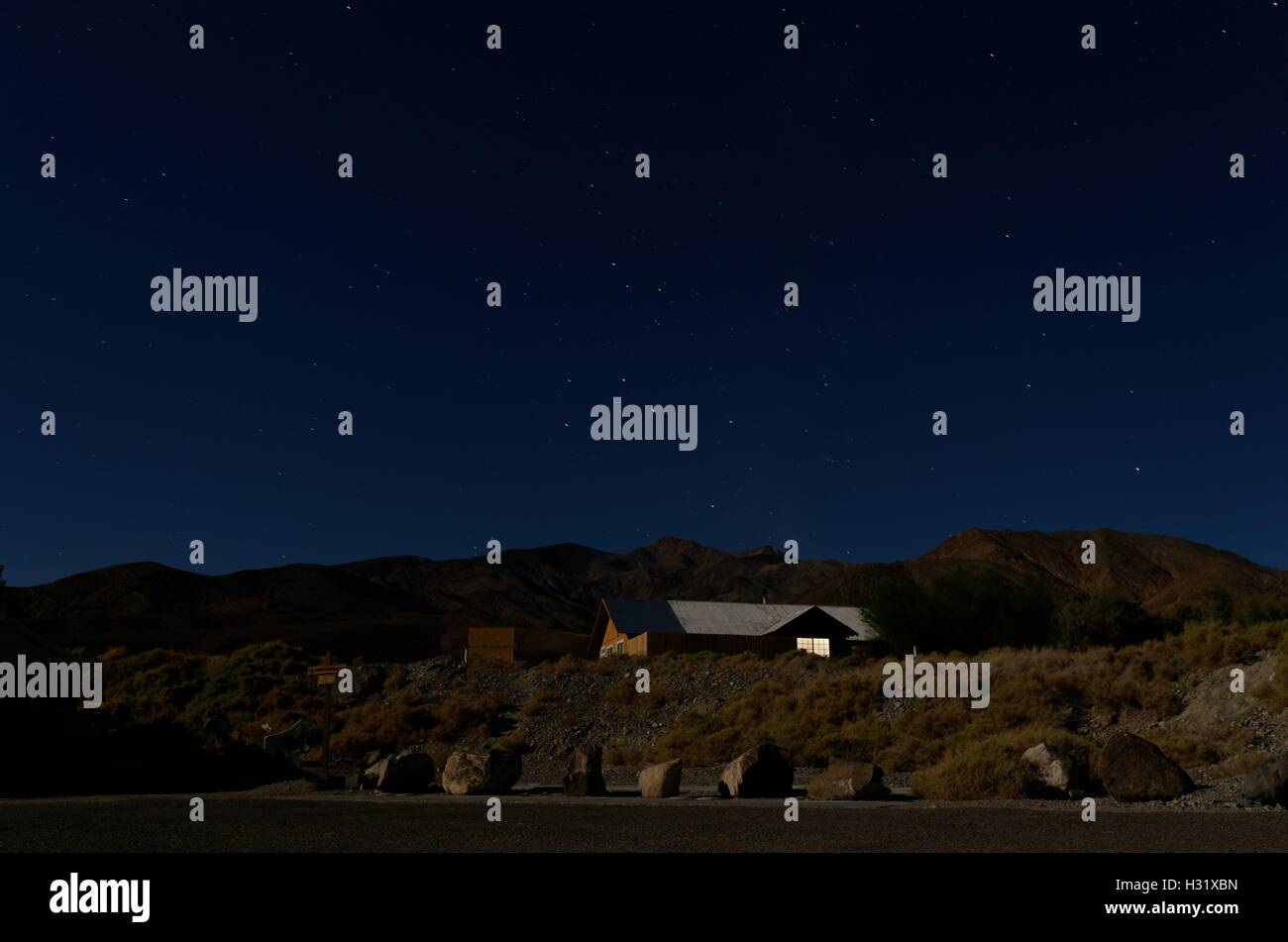 Casa in mezzo al deserto di notte con un cielo stellato Foto Stock