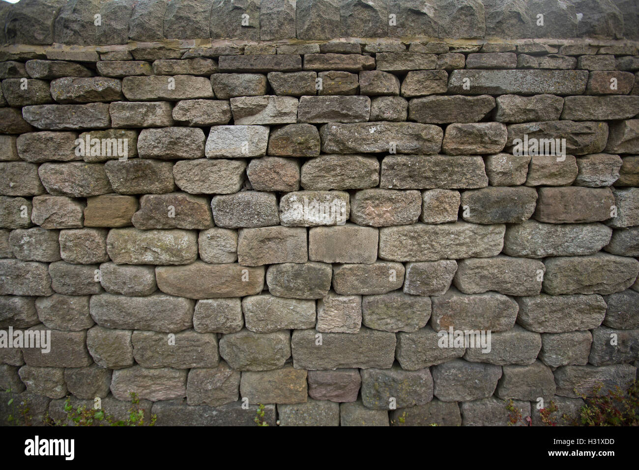 Sezione ad alta vecchio da grigio a marrone pietra secca parete vicino Bamford Inghilterra Foto Stock