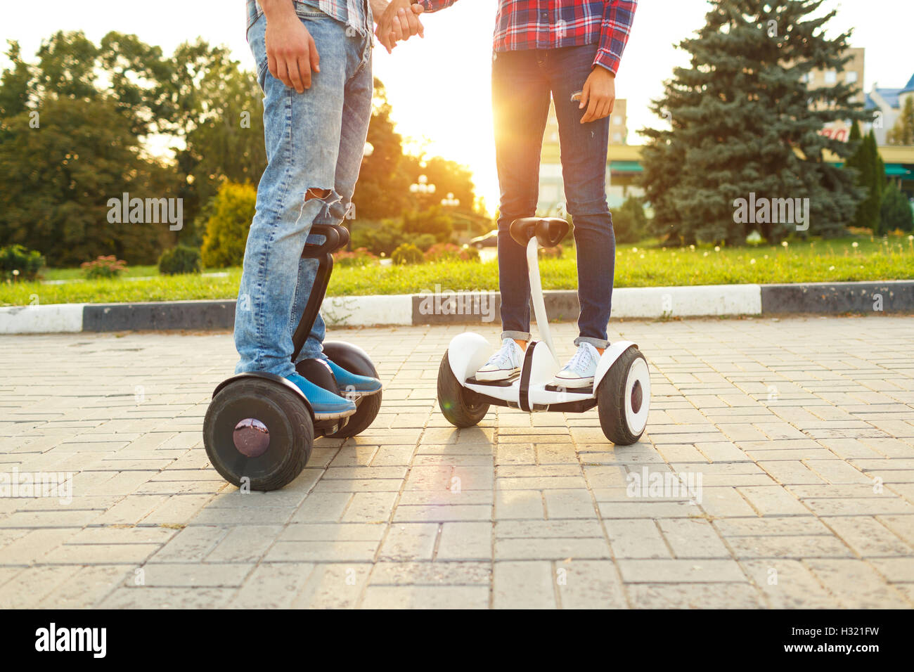 Una giovane coppia in sella hoverboard - scooter elettrici, personale  trasporto eco, giroscopio scooter, smart ruota di equilibrio. Nuova moderna  tec Foto stock - Alamy