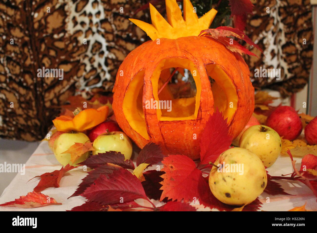 Arancio brillante zucca tagliata in forma di carrello Cenerentola decorata di foglie e di mele per la festa di Halloween Foto Stock