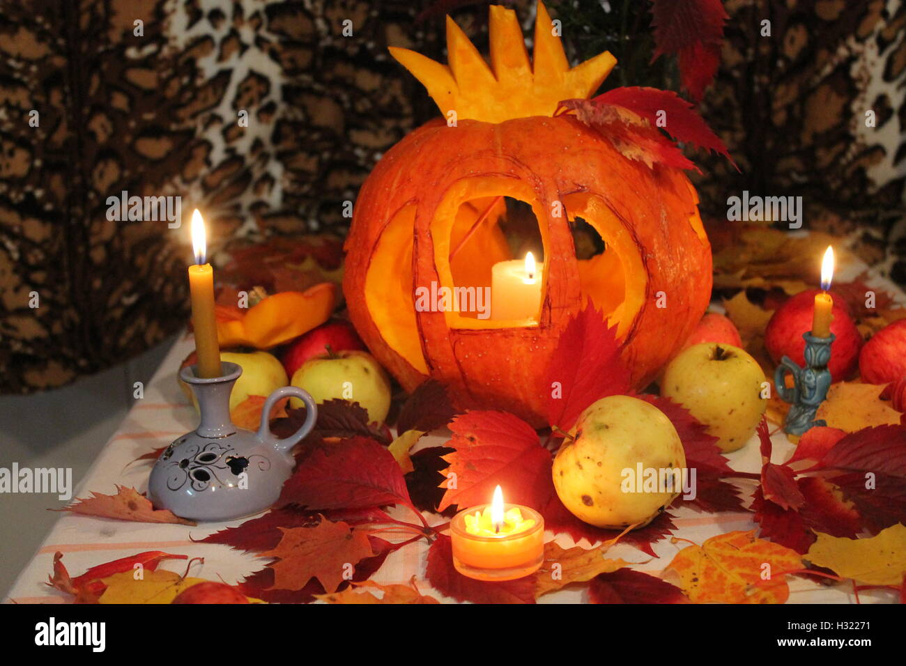 Po' di arancione zucca decorate sotto Halloween lanterna in forma di carrello Cenerentola decorato con candele accese Foto Stock