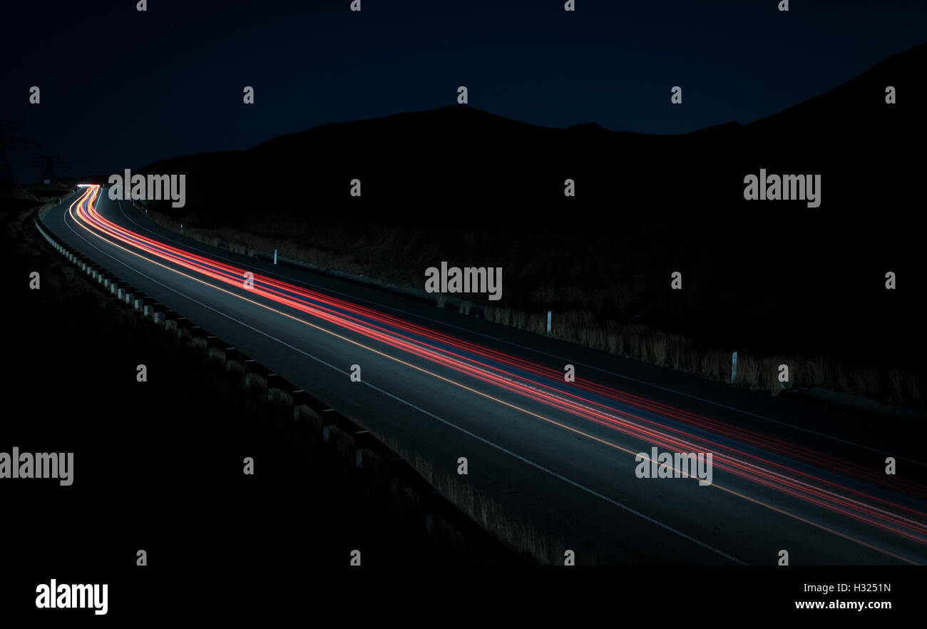 Sentieri di luce dalle automobili si muove velocemente nella tarda serata. Concetto di alta velocità Foto Stock