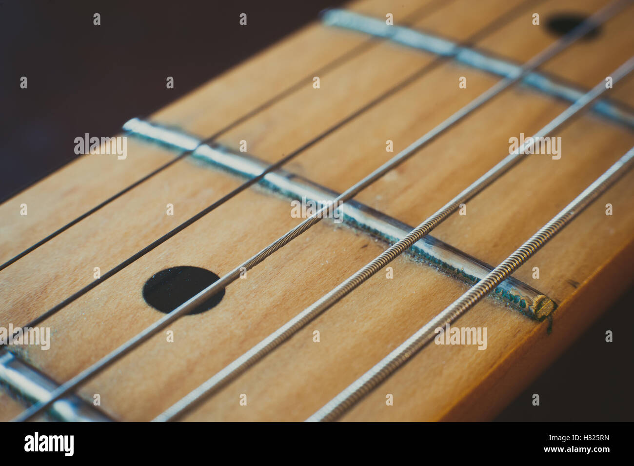 Chitarra elettrica dettaglio collo con effetto di luce, un singolo marcatore punto di messa a fuoco selettiva Foto Stock