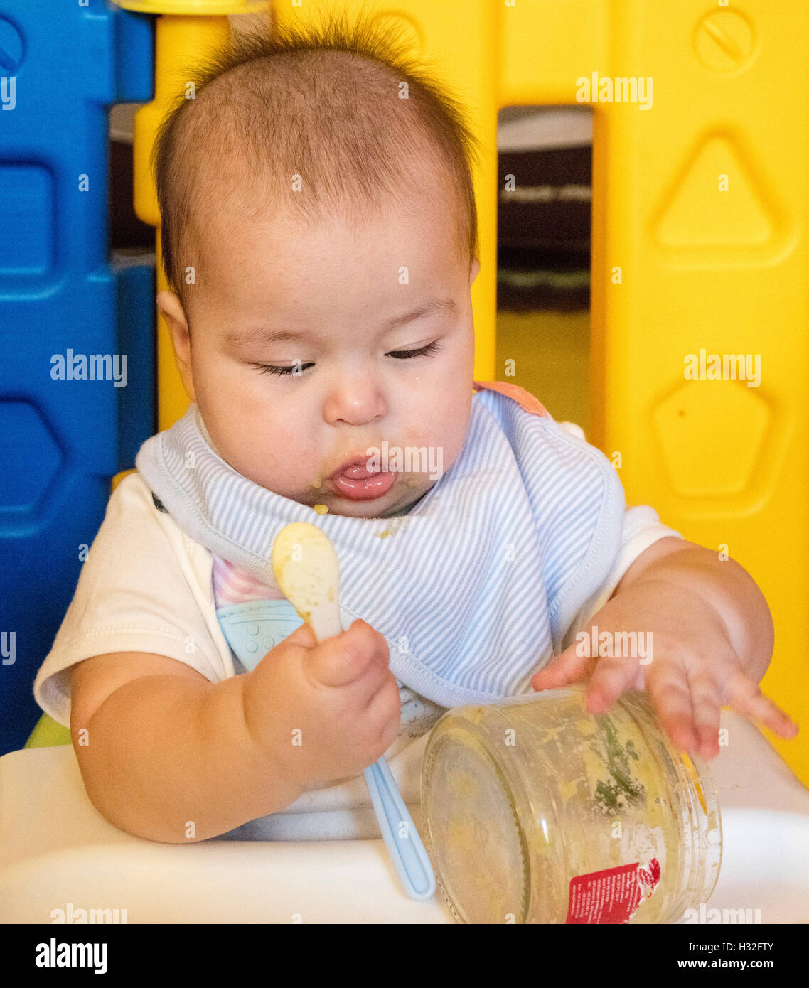 Close up baby giocando con il cucchiaio e jar Foto Stock