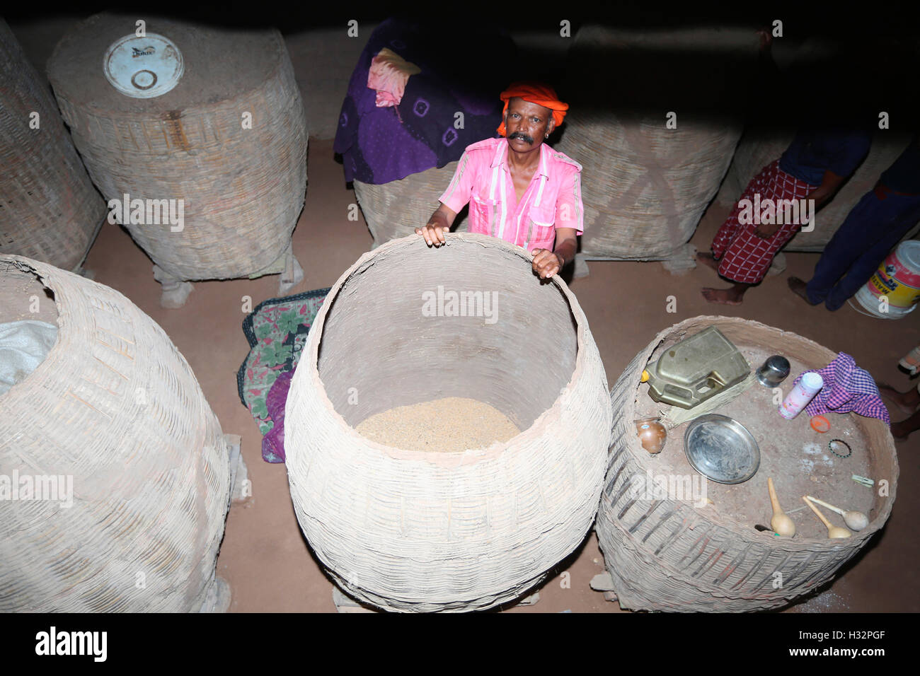 Uomo tribali che mostra grande bambù stoccaggio granella ceste, RATHAWA tribù, Chiliyawat Village, Distretto Chhota Udipur, Taluka, Chhota U Foto Stock