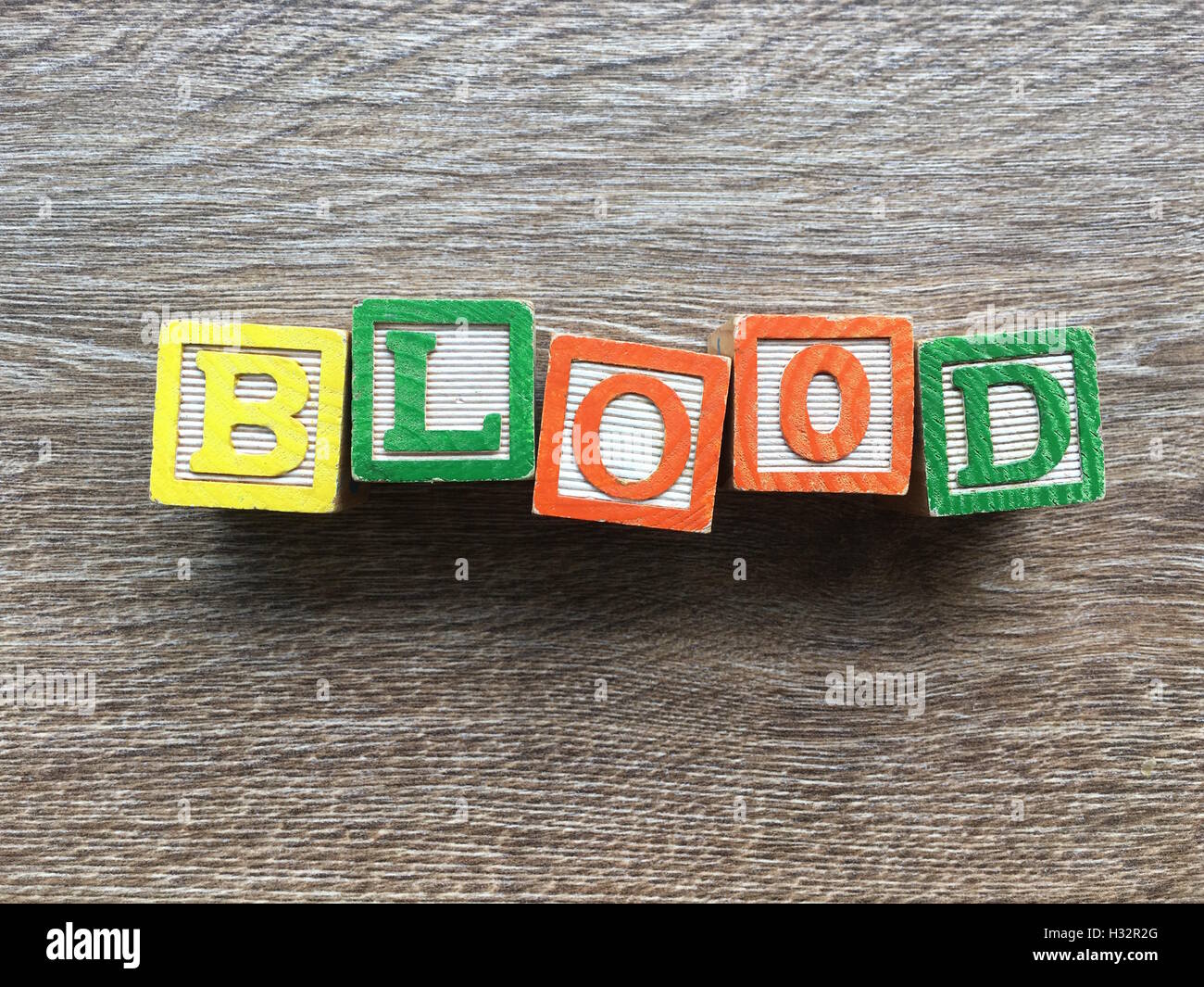 Alfabeto blocco di legno lettere che compongono la parola sangue, è un modo per i giovani i bambini ad imparare le parole in inglese in un modo divertente Foto Stock