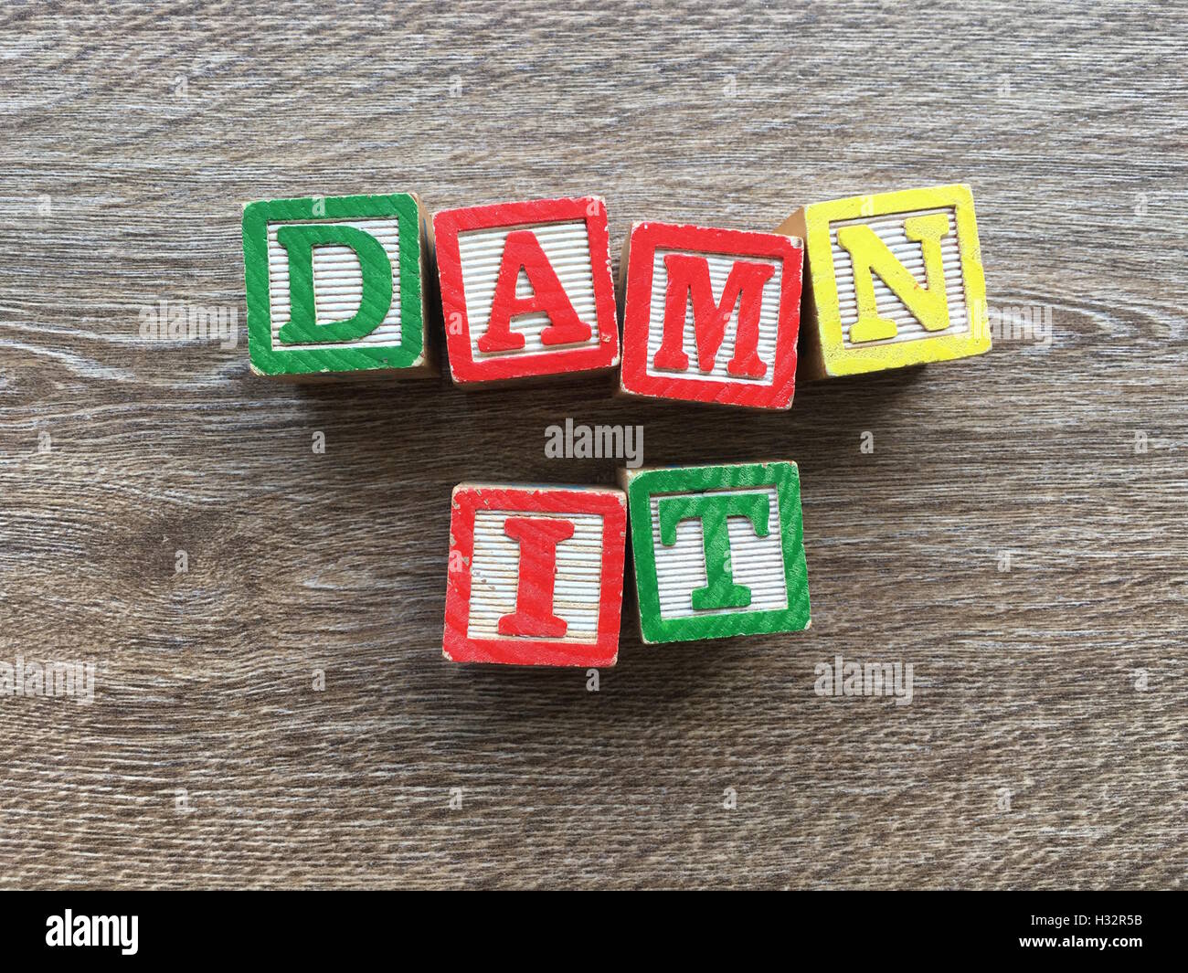 Alfabeto blocco di legno lettere che compongono la parola dannazione, combinando tali giocattoli lettere aiutare i bambini ad imparare e scrivere in inglese Foto Stock