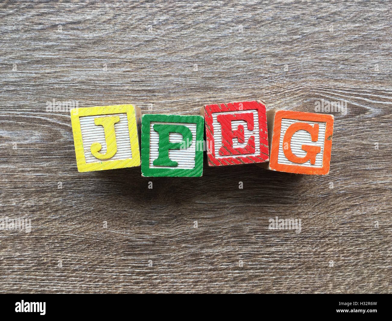 Alfabeto blocco di legno lettere che compongono la parola JPEG per una foto digitale formato, combinare questi giocattoli lettere aiutare i bambini ad imparare e scrivere in inglese Foto Stock