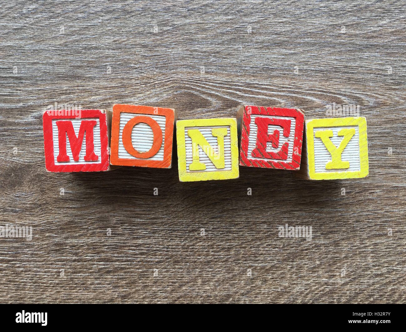 Alfabeto blocco di legno lettere che compongono la parola denaro. Si tratta di una tipografia di stile per creare o imparare parole Foto Stock