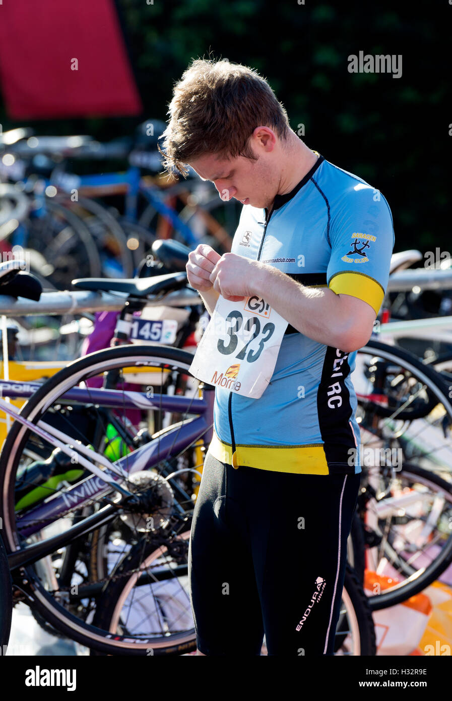 Concorrente maschile mettendo sul numero di gara in Warwickshire Triathlon, Stratford-upon-Avon, Regno Unito Foto Stock
