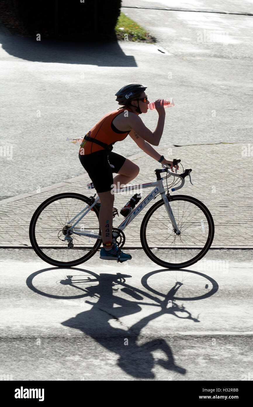 Un concorrente femmina avente un drink nel Warwickshire Triathlon, Stratford-upon-Avon, Regno Unito Foto Stock