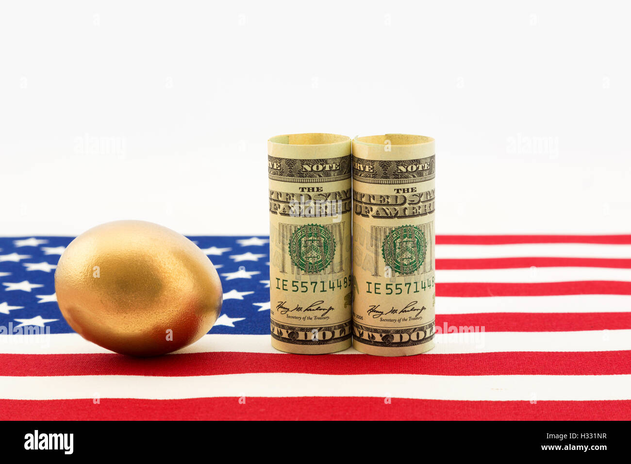 Oro uovo di nido con un paio di dollari americani posto sulla bandiera degli Stati Uniti mostrano il successo del governo nazionale politica e commercio della nazione Foto Stock