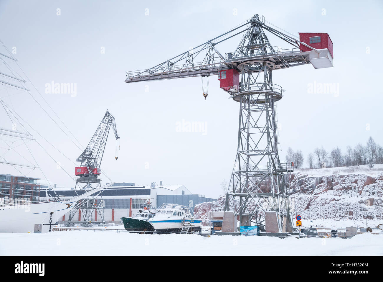 Gru industriali e le navi da carico in wnter porta. Turku, Finlandia Foto Stock