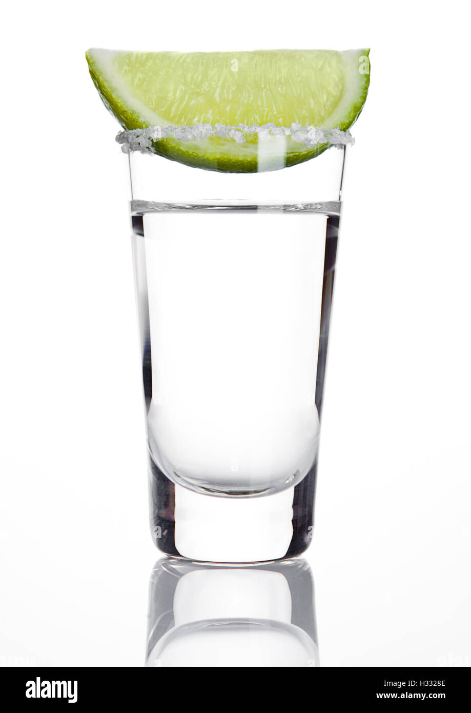 Silver tequila colpo di vetro con fetta di lime e sale su sfondo bianco Foto Stock