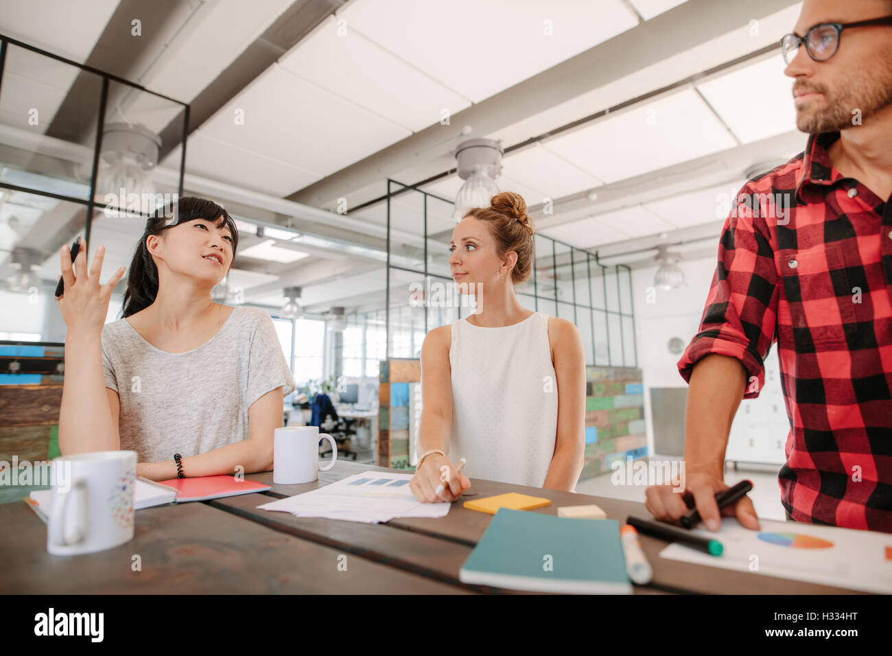 Gruppo di multirazziale i colleghi per discutere di nuove idee di business attorno ad un tavolo in ufficio creativo. Foto Stock