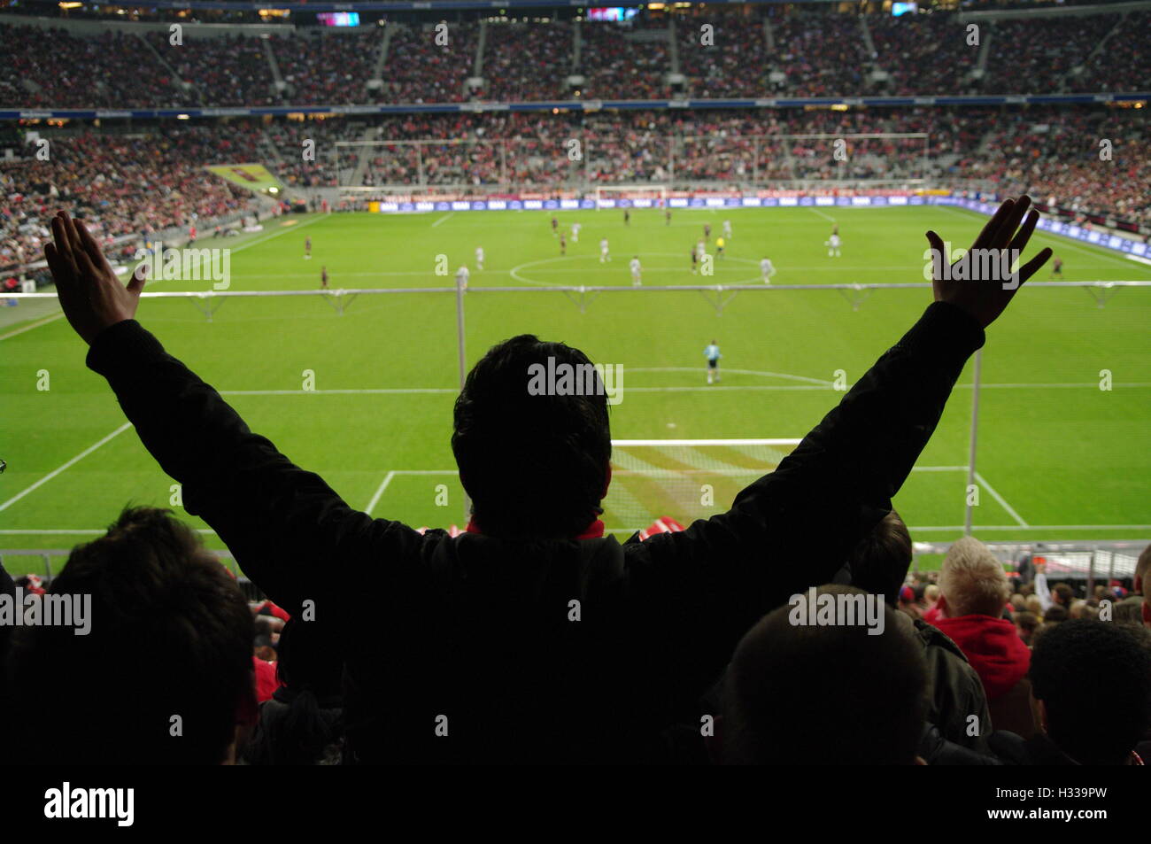 Gli spettatori in uno stadio durante una partita di calcio Foto Stock