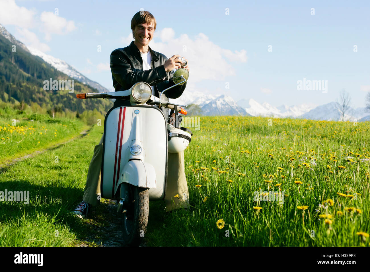 L'uomo, 29, su un classico scooter, Allgaeu, Bavaria Foto Stock