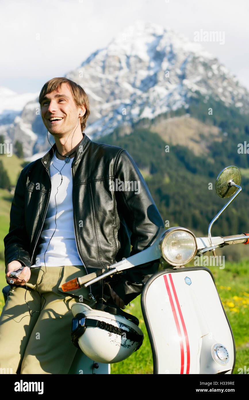L'uomo, 29, su un classico scooter, Allgaeu, Bavaria Foto Stock