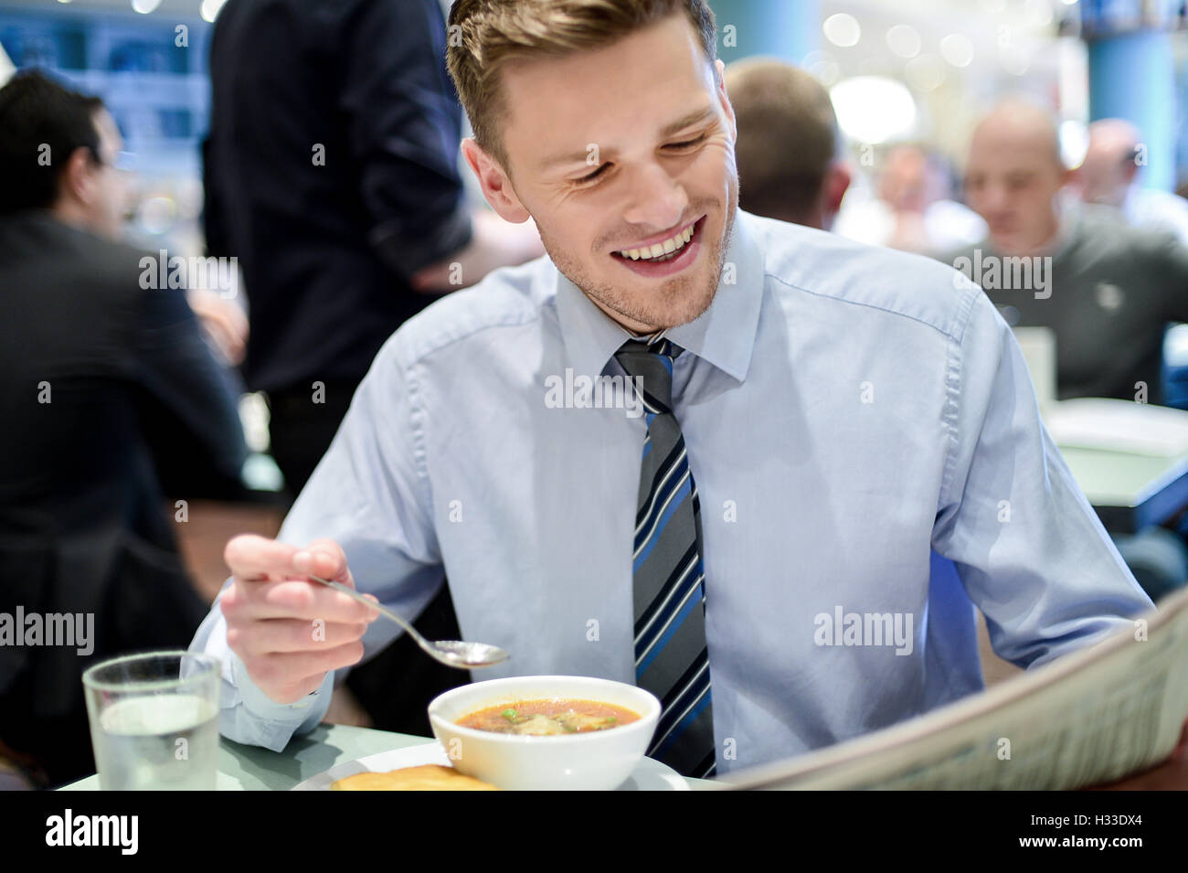 Sorridente giovane imprenditore in un ristorante Foto Stock