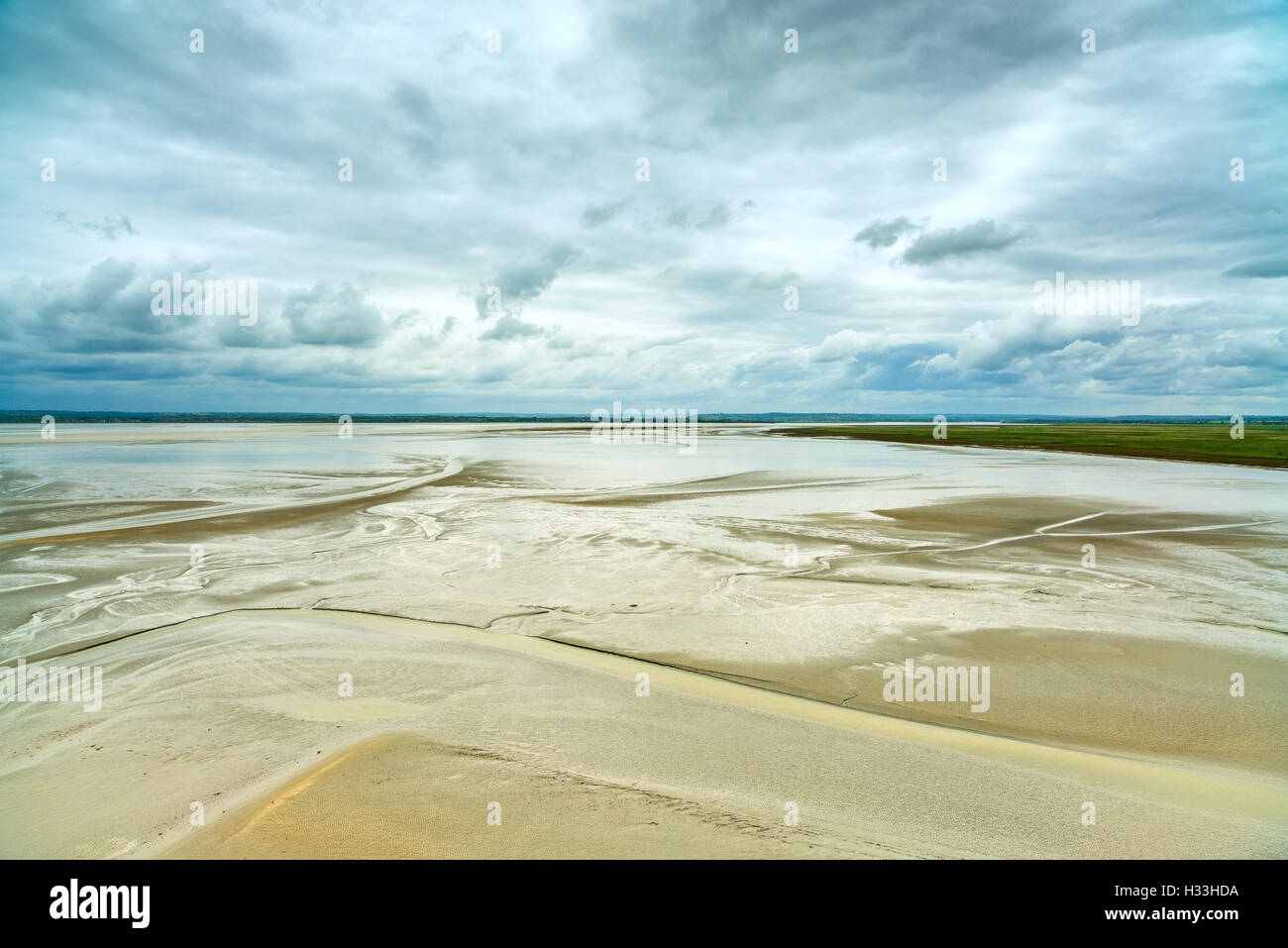 La bassa marea e monastero dettaglio nella baia di Mont Saint Michel landmark. I turisti attraversare la baia. La Normandia, Francia, Europa Foto Stock