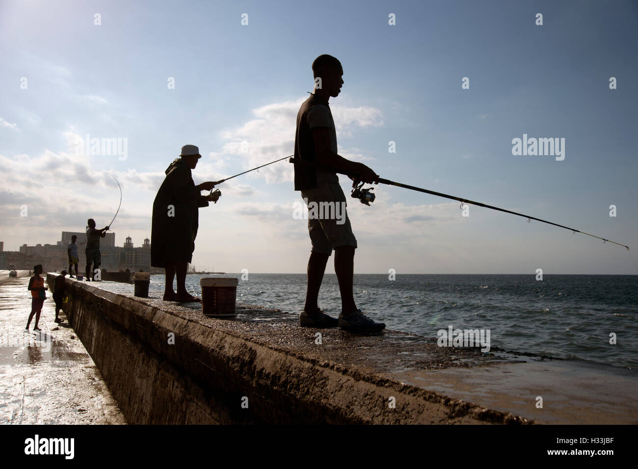 Un gruppo di pescatori cubano stagliano sulla parete del mare sul Malecon in Havana Cuba Foto Stock