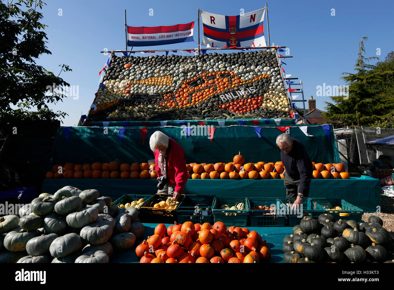 Shoppers guardare attraverso le zucche di fronte a un gigante immagine di un Royal National scialuppa di salvataggio Institutio (RNLI) scialuppa di salvataggio realizzato interamente Foto Stock