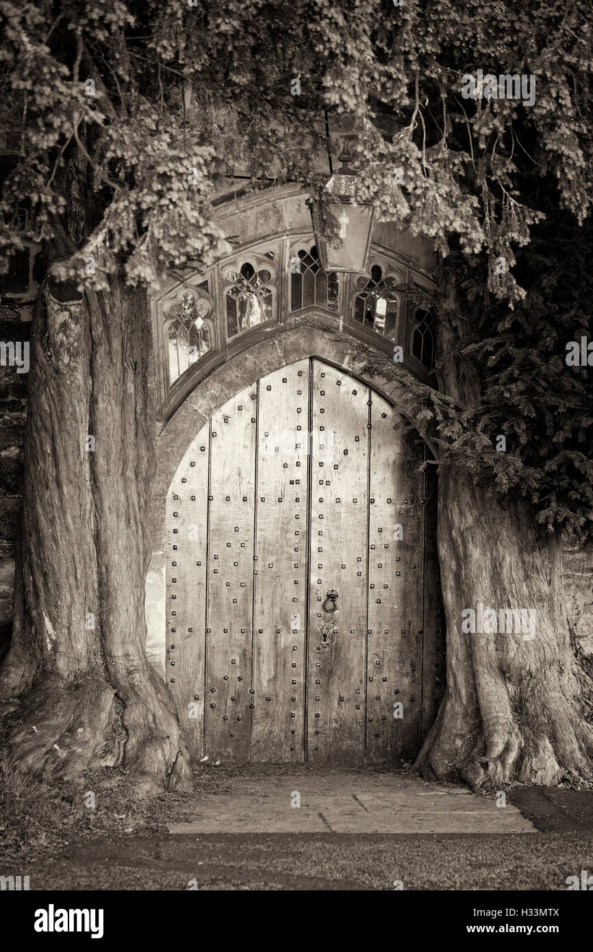 Bellissima chiesa in legno porta impostata tra due alberi di tasso in Stow on the wold Foto Stock