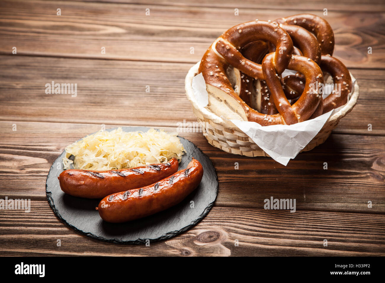 Salatini, il bratwurst e crauti sul tavolo di legno Foto Stock