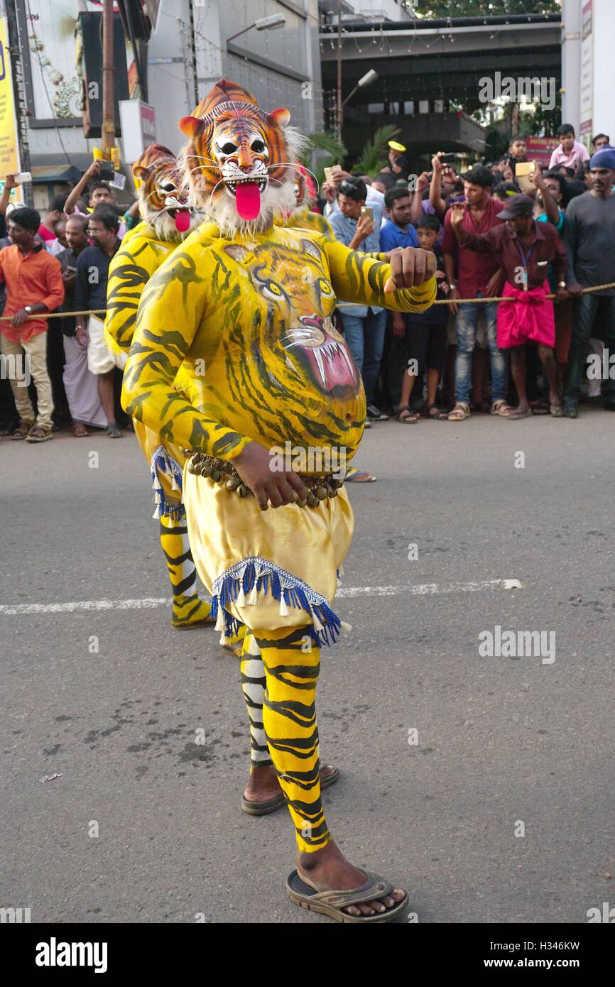 Addestrati danzatori con loro accuratamente i corpi verniciati pretesto di tigri eseguire il famoso Pulikali le strade di Thrissur Kerala Foto Stock