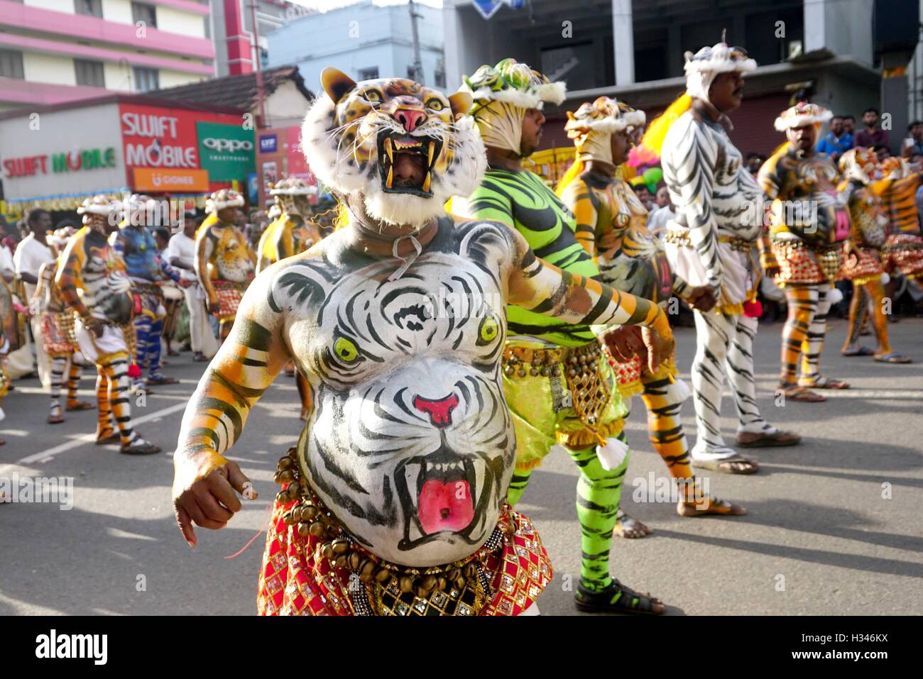 Addestrati danzatori con loro accuratamente i corpi verniciati pretesto di tigri eseguire il famoso Pulikali strade di Thrissur Kerala Foto Stock