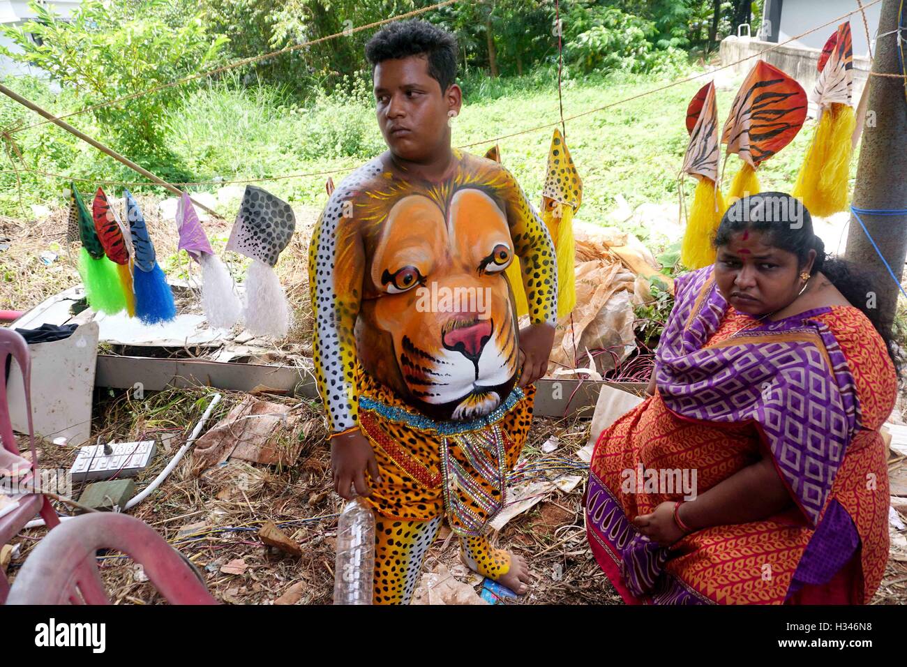 Un ballerino qualificato ottiene il suo corpo verniciato nei colori tiger si prepara a partecipare al famoso Pulikali Thrissur Kerala Foto Stock