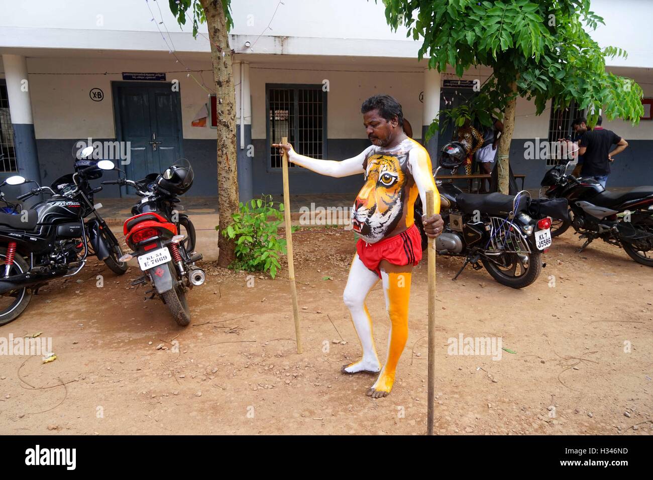 Un ballerino qualificato ottiene il suo corpo verniciato nei colori di una tigre si prepara a partecipare famoso Pulikali Thrissur Kerala Foto Stock