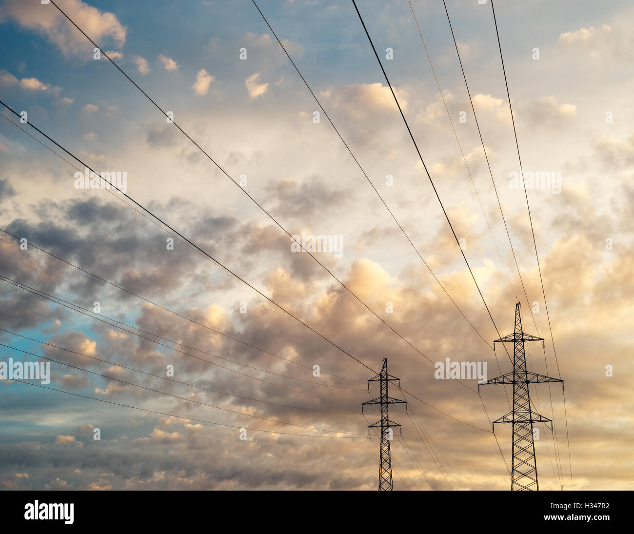 Linea ad alta tensione contro la scenic cloudscape, colorato sunrise sky Foto Stock