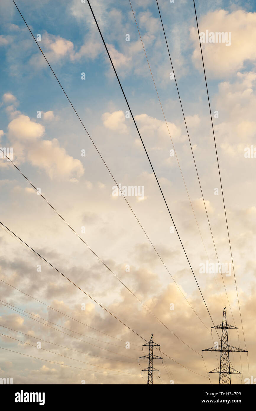 Linea ad alta tensione contro cloudscape su sunrise, composizione verticale Foto Stock