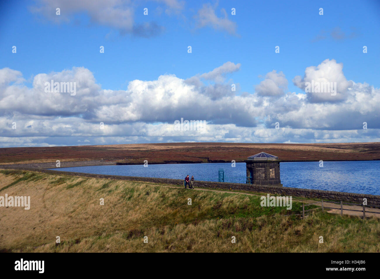 Un giovane camminando sul serbatoio di masticare parete Dam Saddleworth Moor, Parco Nazionale di Peak District, Greater Manchester, Inghilterra England Regno Unito. Foto Stock