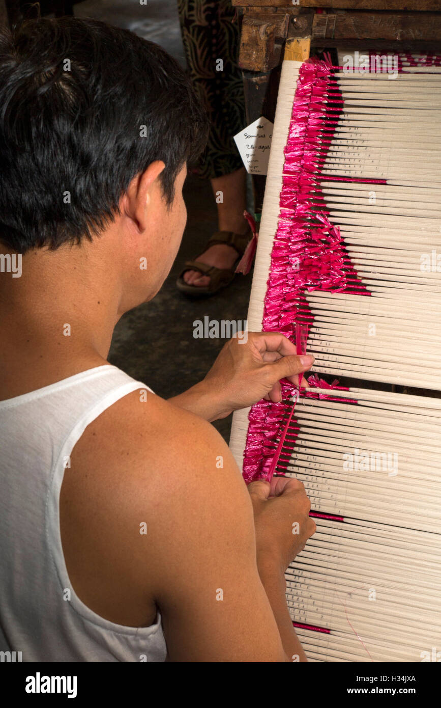 Indonesia, Bali, Singaraja, Pertenunan Berdikari atelier di tessitura, lavoratore legatura a mano colorante filettature di resist Foto Stock