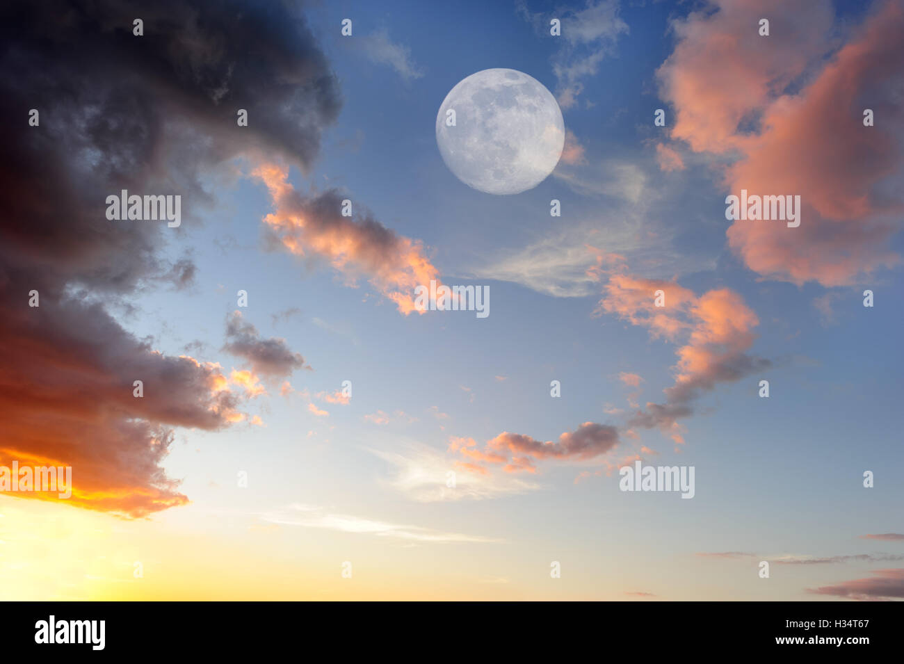 Nuvole luna è una vibrante colorata cloudscape al tramonto con una ethereal Full Moon Rising nel cielo. Foto Stock