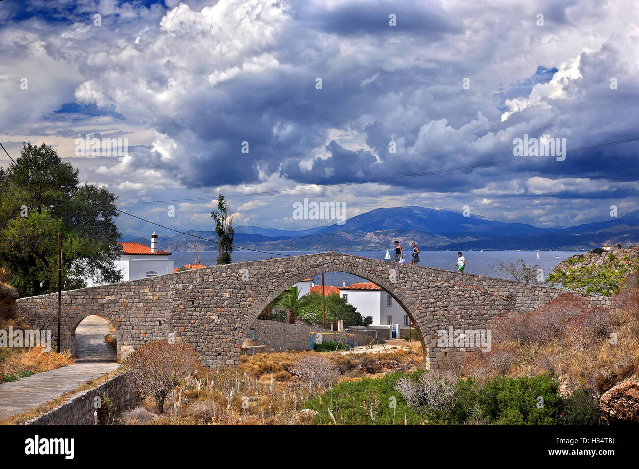 Antica pietra ponte arcuato a Vlychos village, Hydra Island, Attica, Grecia. Foto Stock